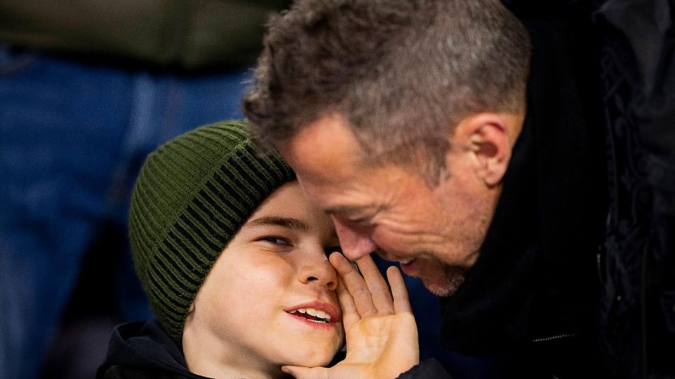Milan Matthäus flüstert seinem Vater bei einem Stadionbesuch etwas ins Ohr.