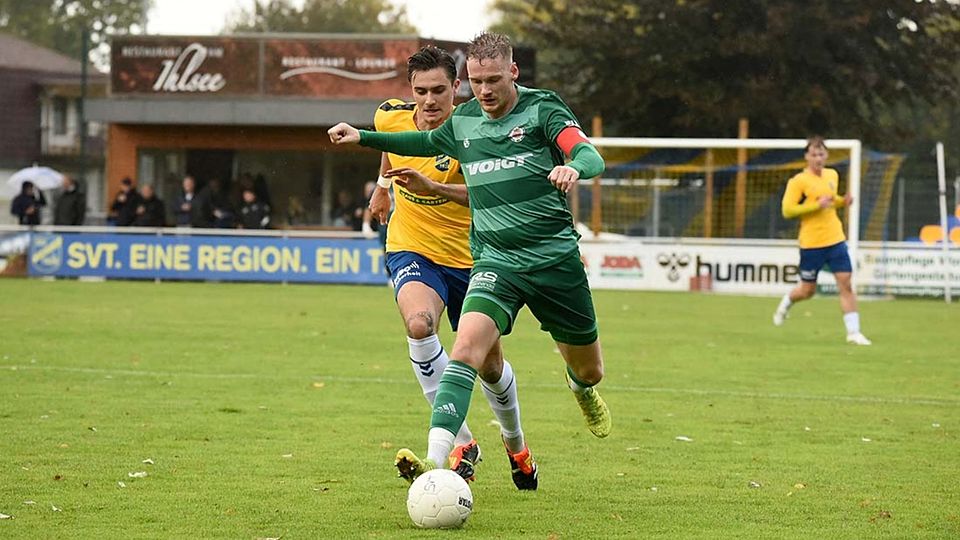 Timo Barendt (am Ball, PSV Neumünster) im Laufduell mit Lasse Jetz (SV Todesfelde).