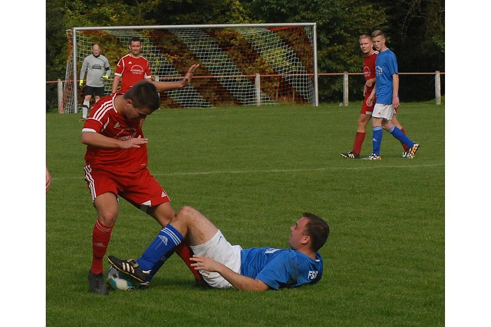 Jan Müller (FSG Lumda/Geilshausen) versucht den Ball am Boden liegend vor Gegenspieler Jonas Becker (TSG Nieder-Ohmen, links) zu sichern. 	Foto: Niebergall