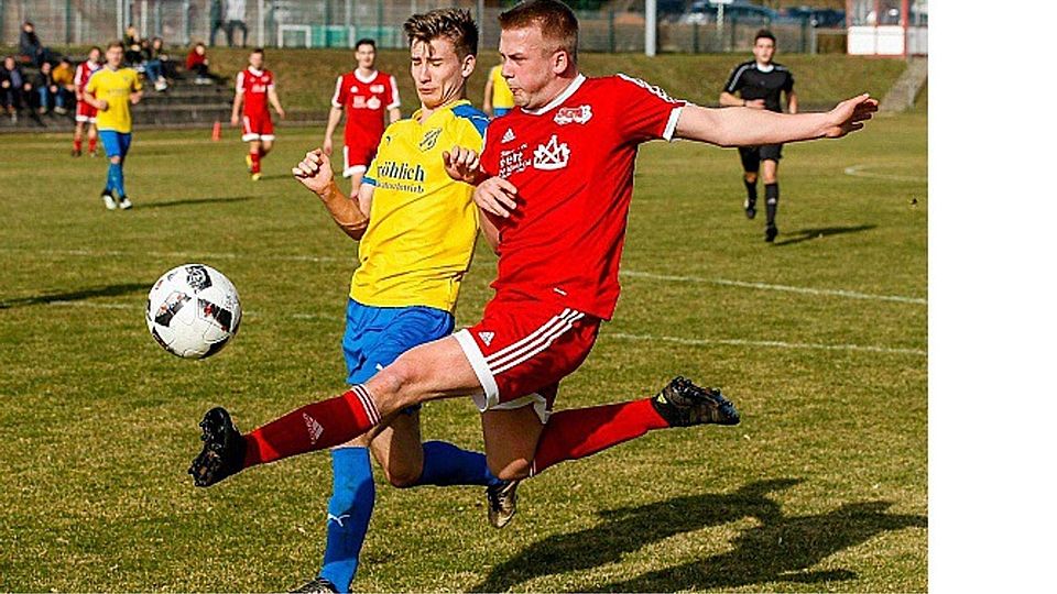 Durchgesetzt: Hüffelsheims Sebastian Fett (rotes Trikot) kommt im Sprung vor seinem Gegenspieler an den Ball.	Foto: Dirk Waidner