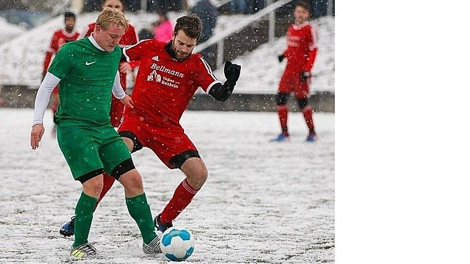 Spiel im Schnee: SG-Kapitän David Lukas (links) gewinnt den Zweikampf gegen Rüdesheims Patrik Schäfer.	Foto: Dirk Waidner