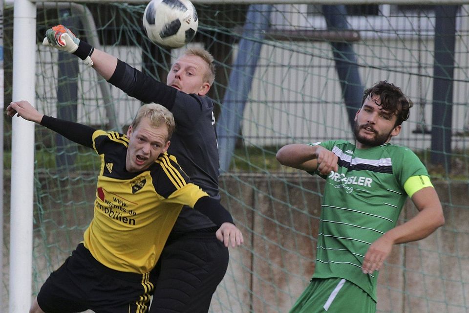Marius Welp (in Schwarz) klärt gegen Andy Engelmeyer (gelb). Kapitän Yannick Lietzke schaut zu.