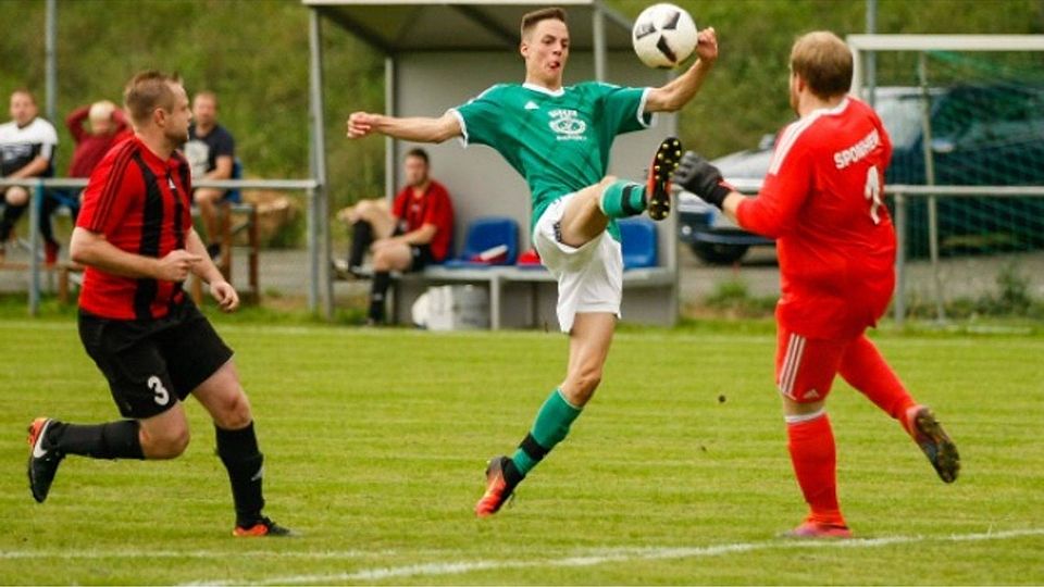 Gekonnt zur Führung: Wallhausens Nico Bösel (grünes Trikot) hebt den Ball über VfL-Torwart Jonas Bornschein hinweg und erzielt anschließend im Duell mit Sebastian Grünewald (links) das 1:0. Am Ende setzte sich jedoch der VfL Sponheim durch. Foto: Dirk Waidner