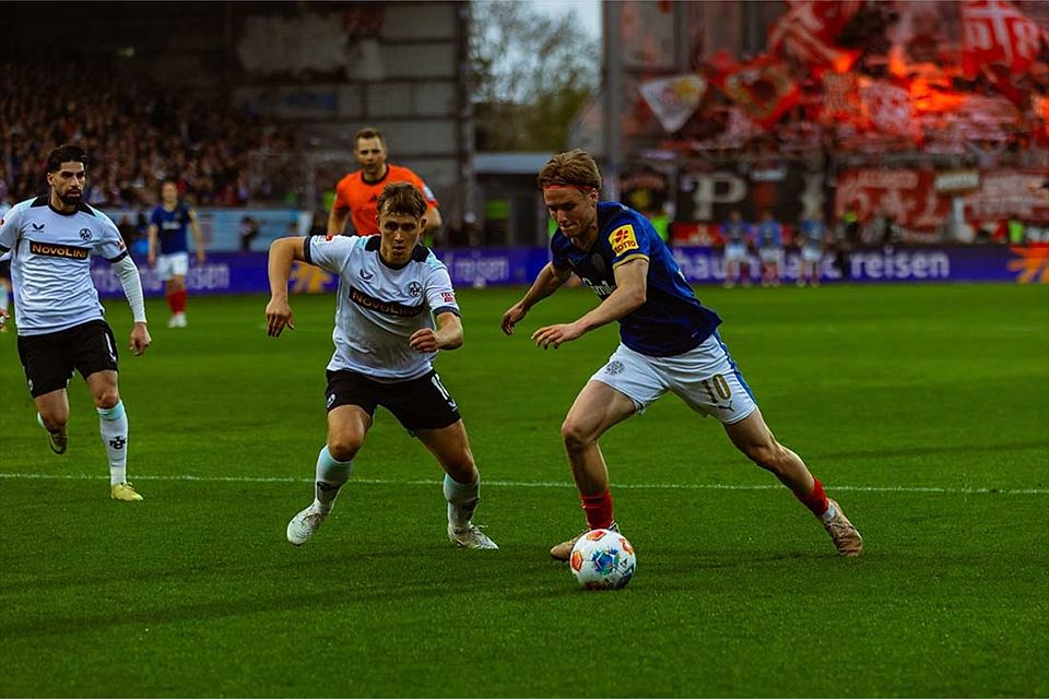 Der eingewechselte Jonas Therkelsen (Holstein Kiel) bringt ordentlich Schwung mit. Links Naatan Skyttä (1. FC Kaiserslautern) im Zweikampf mit dem Kieler.