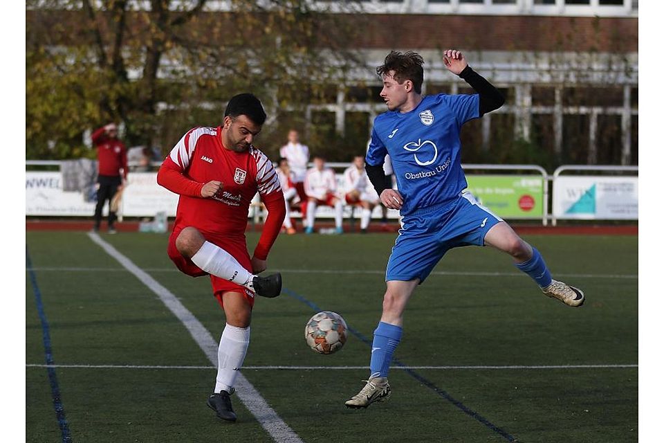 TuS-Spieler Rene Novo (links) spielt den Ball am Leiselheimer Leon Schneider vorbei. Dieser springt vergebens.	Foto: Dirigo/pakalski-press