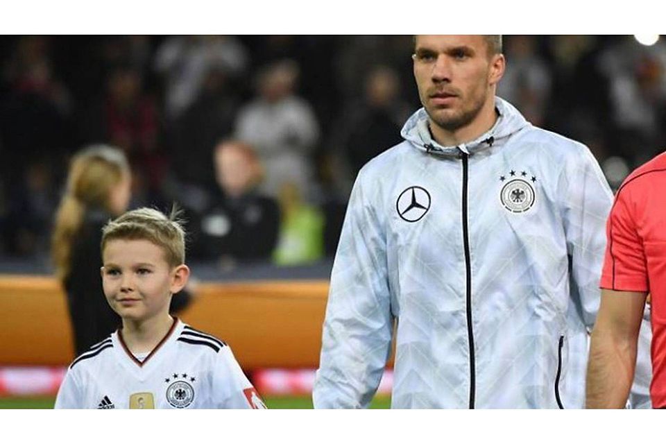 Jakob, Junge aus Bad Kreuznach (l.), an der Hand von Fußballer Lukas Podolski bei dessen Abschiedsspiel aus der Nationalmannschaft. Foto: Jan Hübner