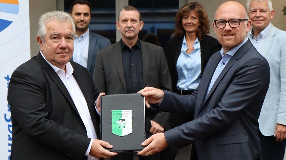 Peter Frymuth (vorne links), Präsident des Fußballverbandes Niederrhein, übergibt die Verpflichtungserklärungen an Duisburgs Oberbürgermeister Sören Link (vorne rechts). Im Hintergrund (v.l.): Christopher Mainka, Jürgen Dietz, Susanne Hering und Martin Linne.