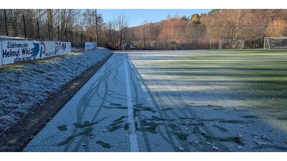 Die Sonnenstrahlen über dem Strohberg in Weidenhausen finden an den Längsseiten des Kunstrasenplatzes keine Angriffsfläche, um die überfrorenen Kunstfasern aufzutauen. Das Risiko für Material und Mensch ist deshalb zu hoch für ein Fußballspiel. © Jan Roth