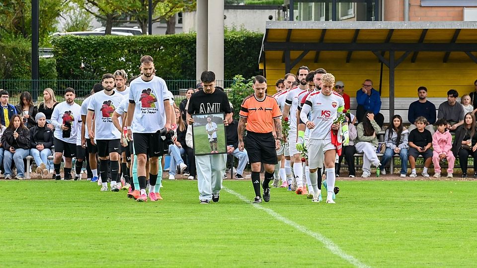 Der Moment des Einlaufens: Die Teams, der Schiedsrichter sowie Furkan Almazoglu mit einem Bild seines Bruders betreten den Rasen zu Ehren von Fevzi.