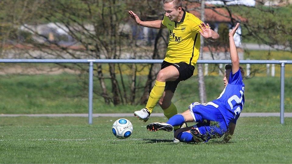 Denkingens Marcel Lienemann (gelbes Trikot) wird vom Immenstaader Lucas Haug attackiert. Die hohe Einsatzbereitschaft der stark abstiegsgefährdeten Gäste vom Bodensee zahlte sich letztlich aus, sie gingen in Denkingen überraschend als Sieger vom Rase Foto: Karl-Heinz Bodon