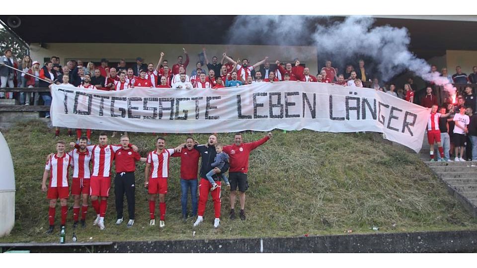 Spieler und Fans des SV Hartenrod nach dem Klassenerhalt in der Relegation: „Totgesagte leben länger“. © Jens Schmidt