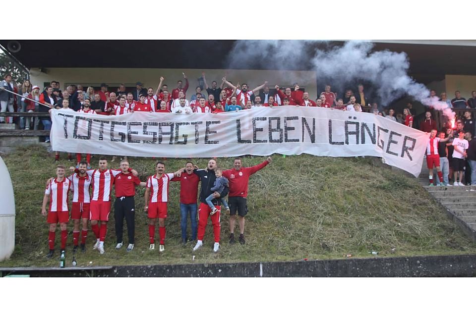 Spieler und Fans des SV Hartenrod nach dem Klassenerhalt in der Relegation: „Totgesagte leben länger“. © Jens Schmidt