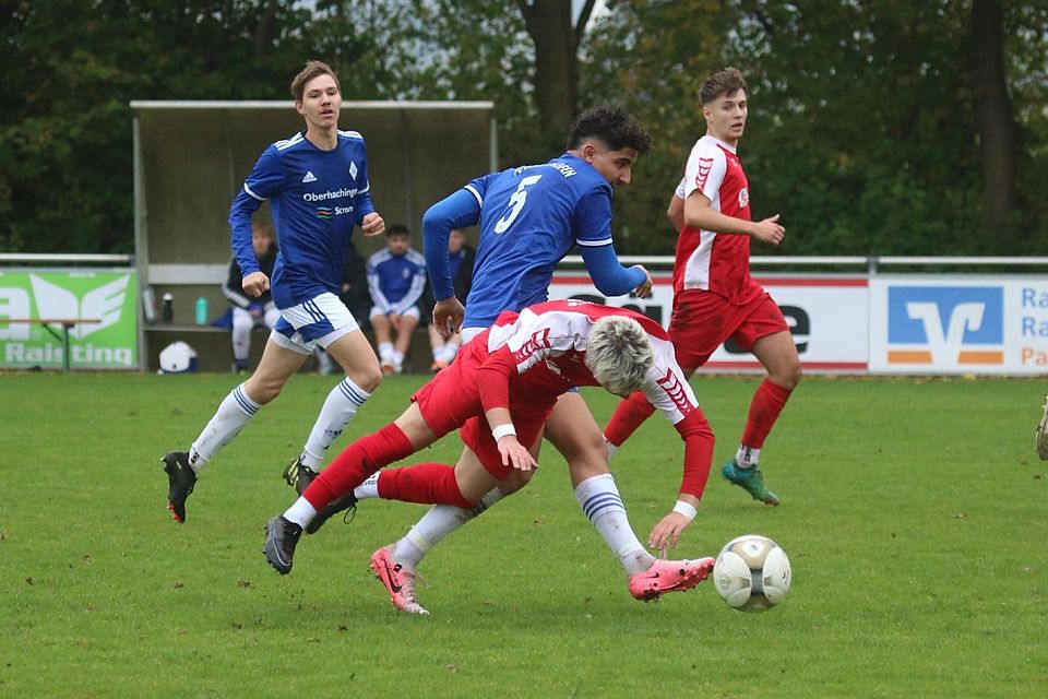 Vinzenz Wolf (rotes Trikot) vom SV Raisting wird im Bezirksliga-Fußballspiel gegen den FC Deisenhofen II unsanft gebremst. Die Partie endete mit 1:1.