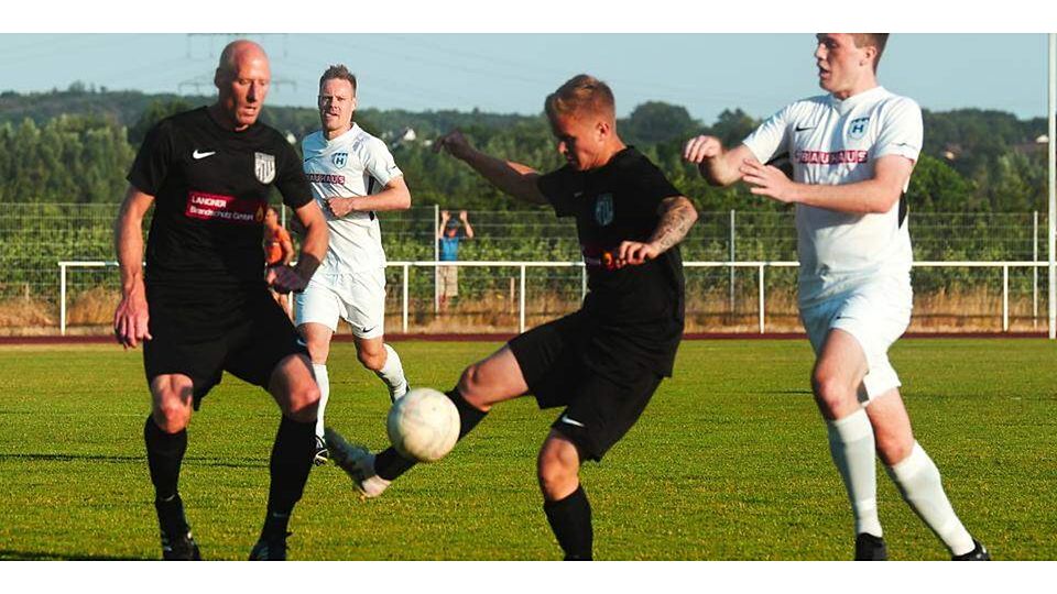  Luca Auth (M.) vom FC Werdorf passt den Ball vor dem Heuchelheimer Paul Rothfuß weiter. (© Peter Bayer) 