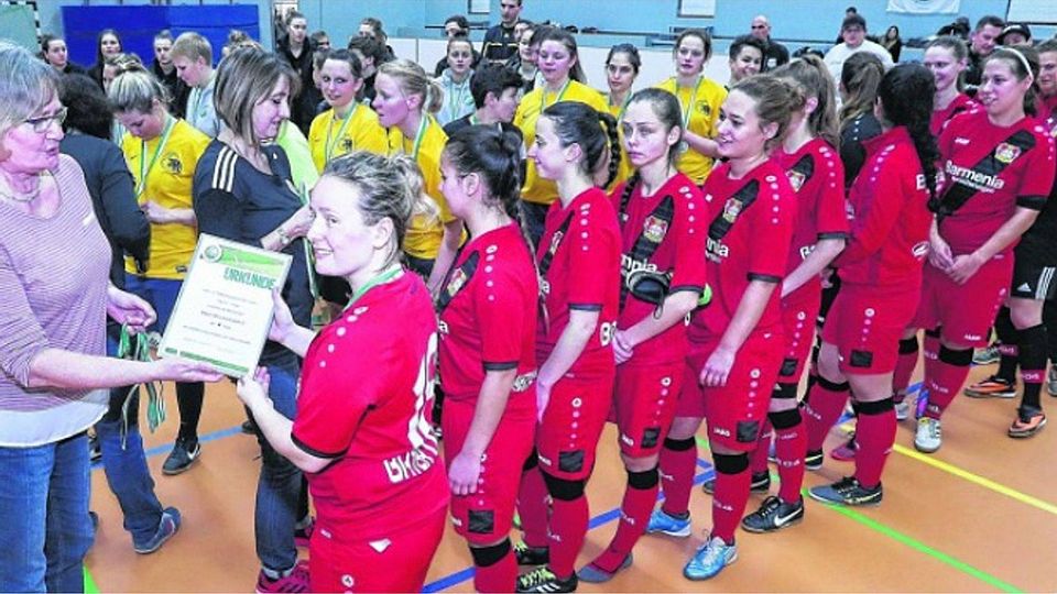 Ursula Sieben, Frauenbeauftragte des Fußballkreises Heinsberg, überreicht Hallenpokalsieger Bayer Leverkusen II Urkunde und Medaillen. Foto: Royal