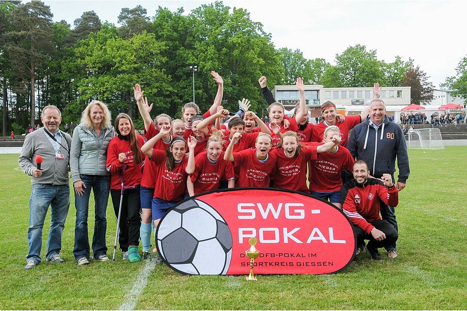 Gruppenbild mit Herren: Henry Mohr und Hans-Peter Wingefeld feiern mit den Frauen von Eintracht Lollar den Pokal-Sieg.